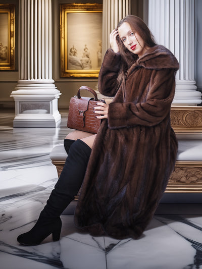 Woman in a brown fur coat holding a handbag in an elegant interior setting.