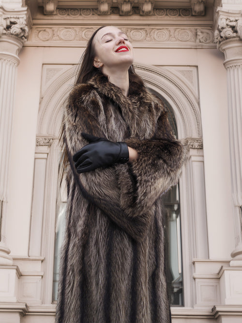 Model wearing Canadian Raccoon Fur Coat in silver tips, showcasing natural fur detail and luxury outerwear appeal in winter setting.