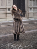 Model in Canadian Raccoon Fur Coat with silver tips, arms crossed for cozy and elegant winter fashion appeal.