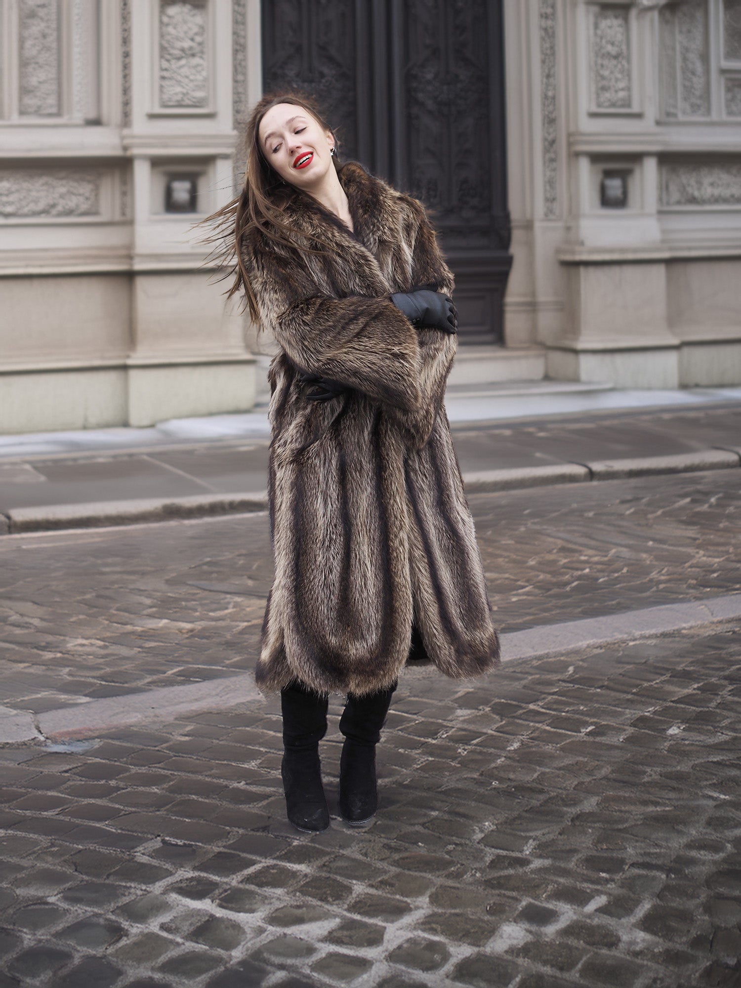 Model in Canadian Raccoon Fur Coat with silver tips, arms crossed for cozy and elegant winter fashion appeal.