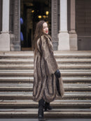 Back view of Canadian Raccoon Fur Coat in silver tips on stairs, highlighting full-length design and elegant winter outerwear.