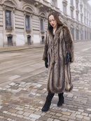 Walking in Canadian Raccoon Fur Coat with silver tips, full-length natural fur outerwear ideal for elegant winter style.