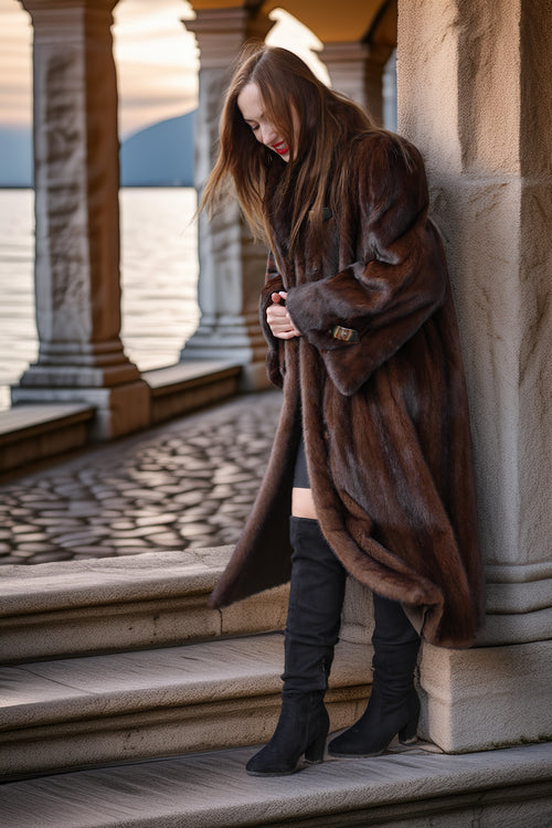 Demi-mink coat in rich brown tone with wide collar, side view on stone steps