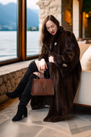 Demi-mink coat in rich brown tone with buttoned front and wide sleeves, seated look