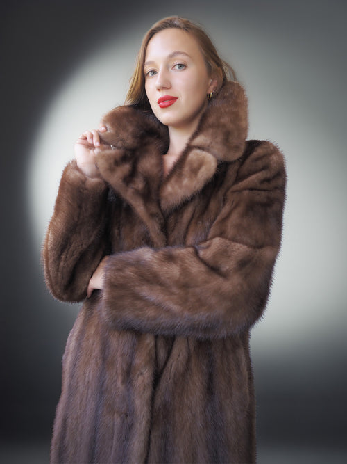 Woman wearing a brown fur coat against a gray background