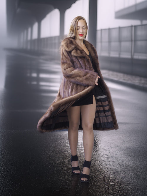 Woman wearing a fur coat on a foggy street