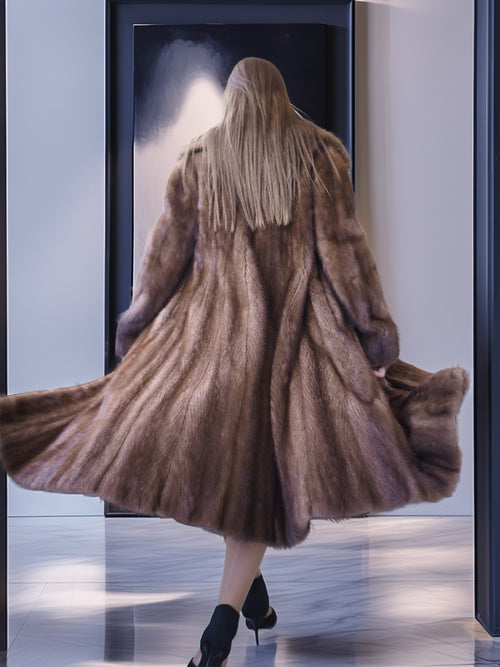 Person wearing a long brown fur coat in a store setting.