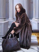 Woman in a fur coat holding a handbag in an elegant interior setting