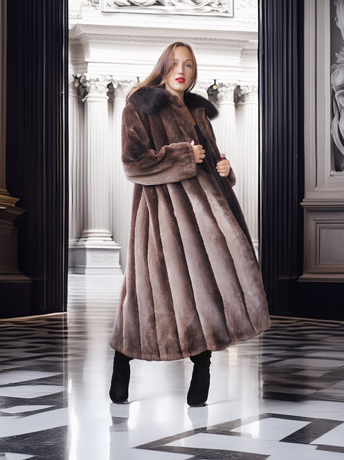 Woman wearing a long brown fur coat in an elegant interior setting