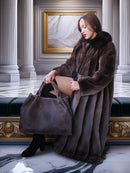 Woman in a fur coat holding a handbag in an elegant interior setting