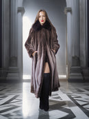 Woman wearing a long fur coat in an elegant interior setting