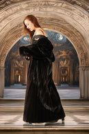 Woman in a black fur coat standing in an ornate architectural setting