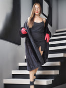 Woman in black outfit with red gloves standing on a staircase