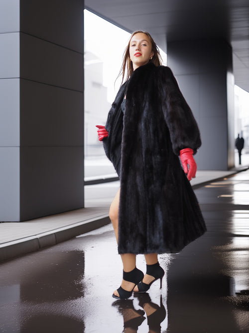 Woman in a black fur coat and red gloves standing on a wet street.