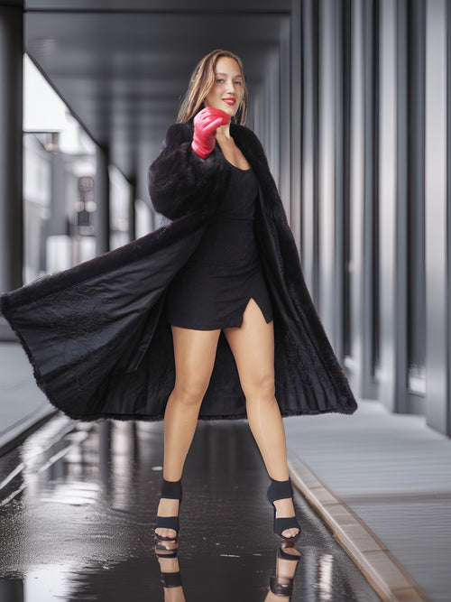 Woman in a black coat and dress with red boxing gloves in an urban setting