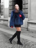 Chic blue fox fur jacket with voluminous sleeves, styled with black thigh-high boots. A luxurious winter coat for sophisticated fashion lovers.