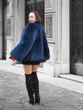 Back view of a plush blue fox fur jacket with voluminous sleeves. A luxurious and warm outerwear choice for winter fashion lovers.