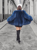 Back view of a luxurious blue fox fur coat with voluminous sleeves. A stylish and warm outerwear choice for winter fashion.