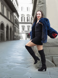 Chic blue fox fur coat draped over shoulders, revealing a black mini dress. A stylish and elegant winter fashion piece.