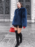 Luxury blue fox fur jacket with a soft crew neck design, styled with red gloves and a black mini skirt. Elegant winter fashion for a bold statement.