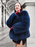 Luxury blue fox fur coat with a plush texture, styled with red gloves. A warm and elegant outerwear piece for winter fashion lovers.