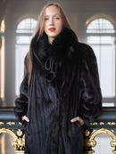 Woman wearing a black fur coat in an elegant interior setting