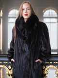 Woman wearing a black fur coat in an elegant interior setting
