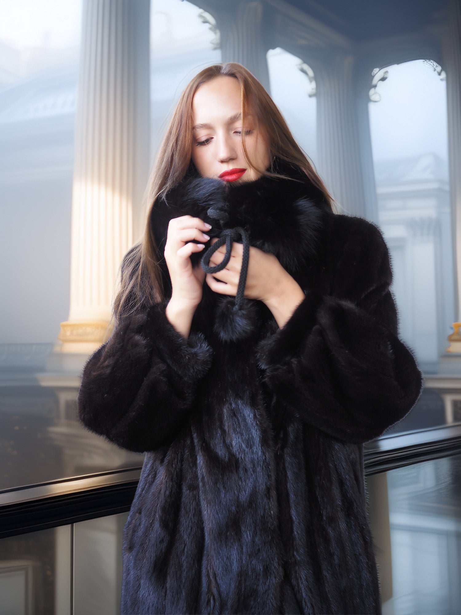 Woman wearing a black fur coat in an elegant interior setting