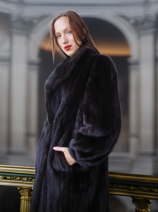 Woman wearing a dark fur coat in an elegant interior setting