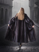 Person wearing a long black coat walking away in a foggy, gothic-style street.
