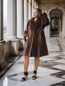 Woman wearing a brown fur coat in an elegant interior setting