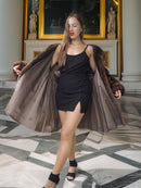 Woman wearing a brown fur coat in an elegant interior setting