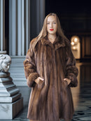 Woman wearing a brown fur coat in an elegant interior setting