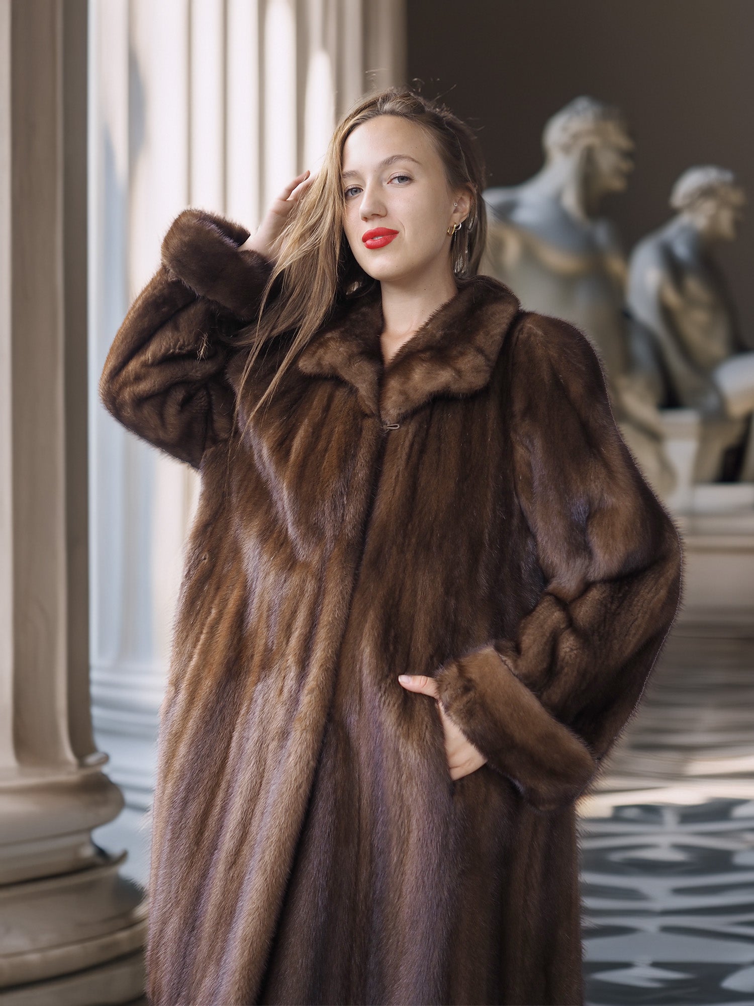 Woman wearing a brown fur coat in an elegant interior setting