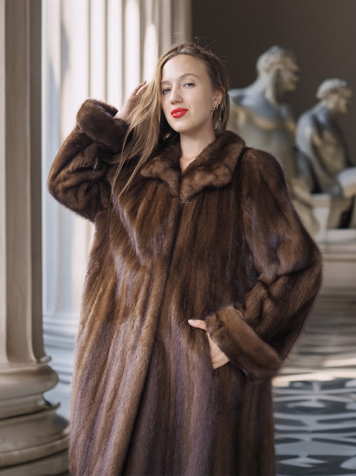 Woman wearing a brown fur coat in an elegant interior setting
