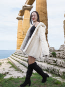 Beige Pearl Mink Fur Coat with hood, worn by a woman near ancient ruins. Elegant and warm outerwear with hook-eye closure and satin lining.