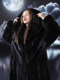 Woman in a black fur coat against a night sky with clouds and moon.