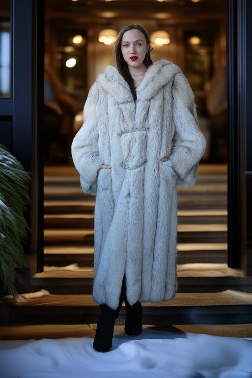Woman wearing a white fur coat standing in a snowy outdoor setting.