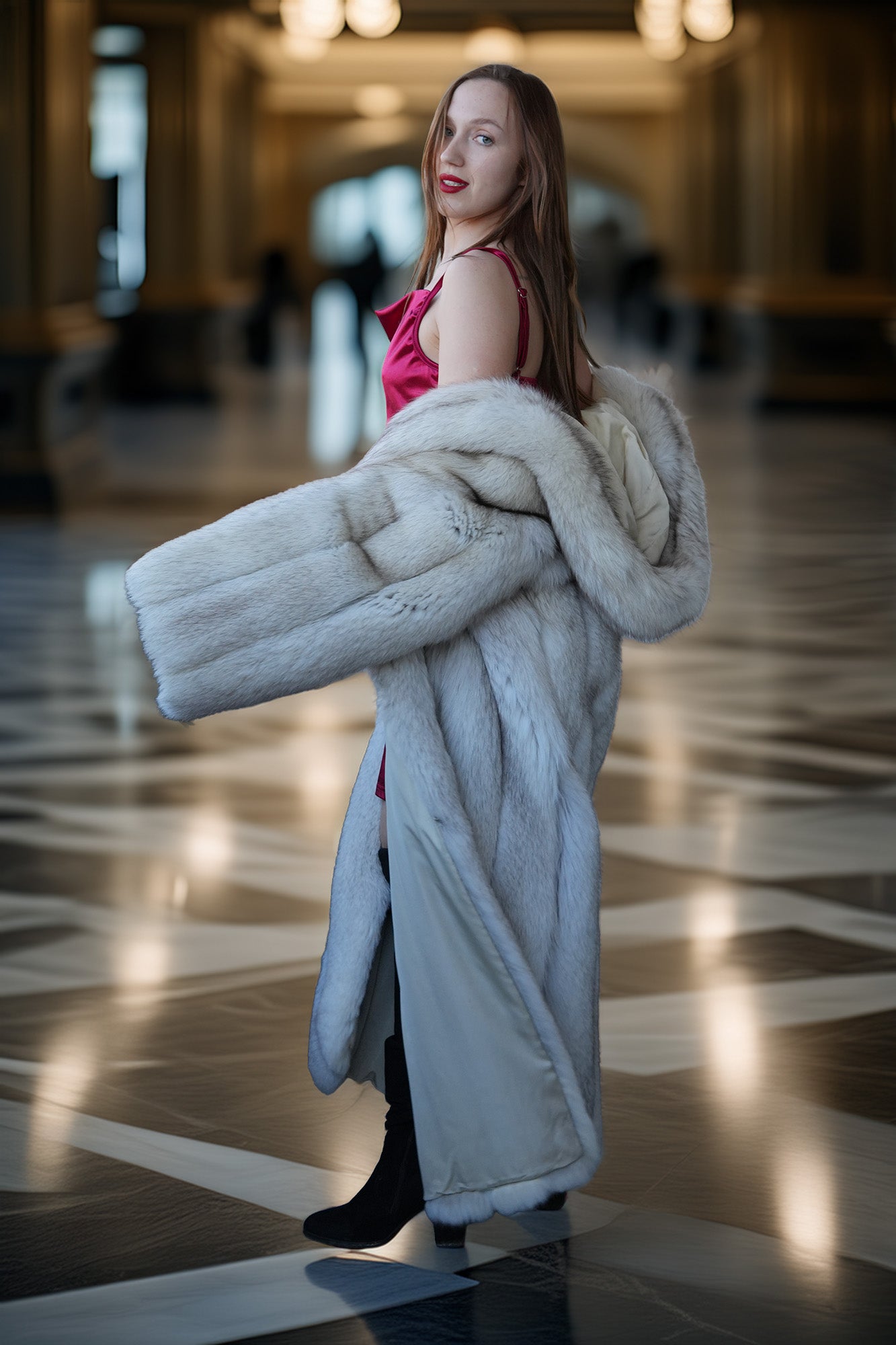 Woman holding a fur coat in an indoor setting with reflective floor and blurred background