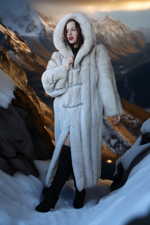 Person wearing a long, fluffy white coat in a snowy mountain setting