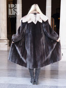Black mink coat with full back drape and light fur collar, standing pose