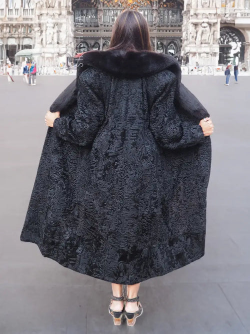Black long fur coat from back view with shawl collar and textured hood-like trim