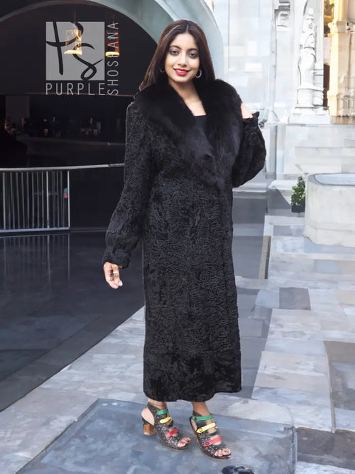 Black textured long fur coat with shawl collar and full sleeves, side view