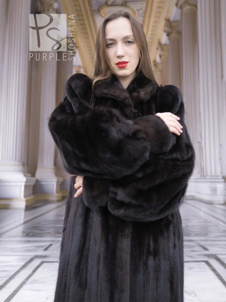 Black mink fur coat with plush high collar and thick cuffs, front crossed-arm view