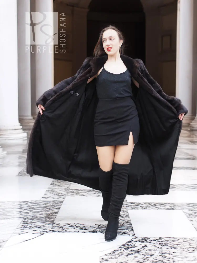 Full-length mink fur coat with draped sleeves and open front, dark black, standing pose