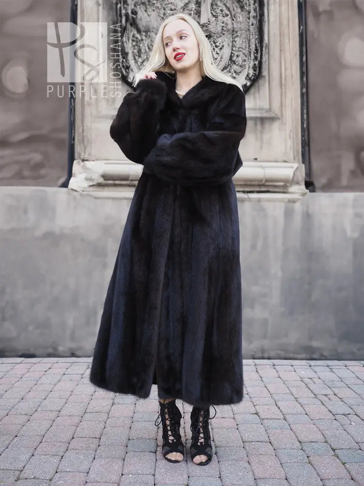 Black mink fur coat, long flared skirt and V-neckline, standing pose.