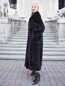 Black mink fur coat, long hooded silhouette with soft, dense fur and front closure.