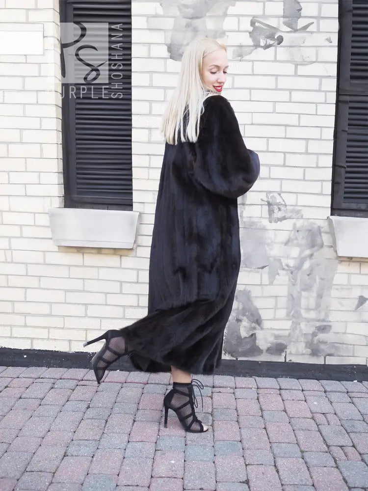 Black mink fur coat, side view showing long hood and wide, flowing sleeves.