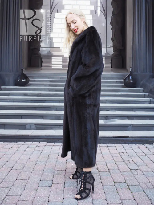 Black mink fur coat, full-length profile with hood and thick fur texture.