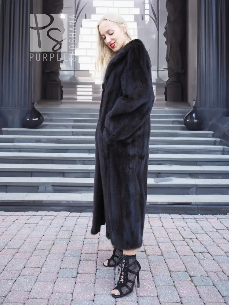 Black mink fur coat, full-length profile with hood and thick fur texture.